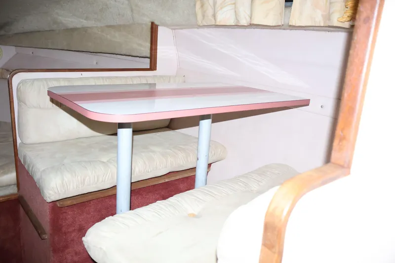 Slide: The Image of Interior of 1990 Thompson 250 Daytona Mid Cabin with cushioned seating and table. - 43