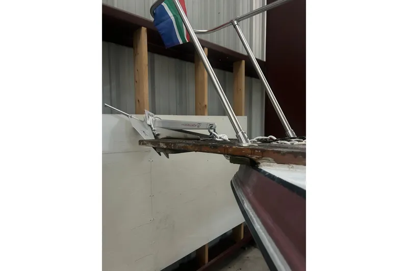 Slide: The Image of 1990 Thompson 250 Daytona Mid Cabin boat with anchor and flag in storage. - 6
