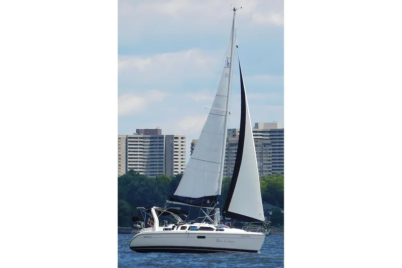 The Image of Sailing yacht Hunter 310 (1998) on water with cityscape background. - 0