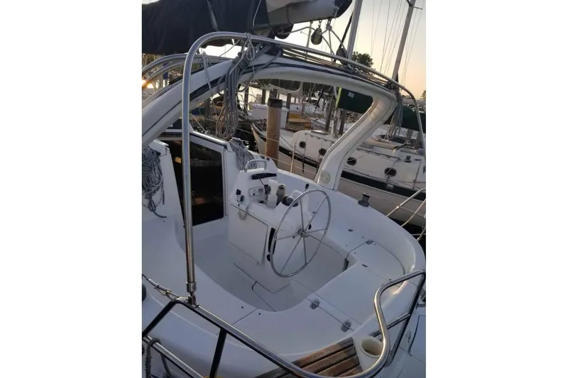 Slide: The Image of 1998 Hunter 310 sailboat cockpit with steering wheel and marina background. - 4