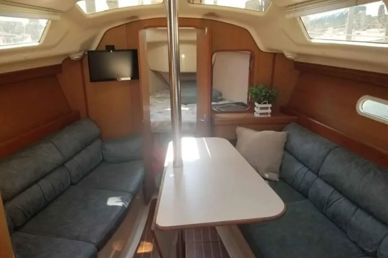 Slide: The Image of Interior of a 1998 Hunter 310 sailboat with cozy seating and a small TV. - 7