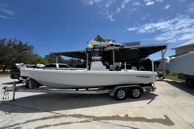 The Image of 2022 Everglades 243 Center Console boat on trailer under clear blue sky. - 1