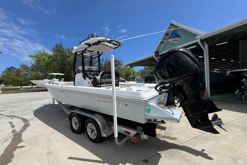 Slide: The Image of 2022 Everglades 243 Center Console boat on trailer, parked outdoors under clear sky. - 14