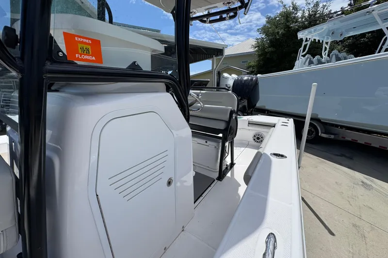 Slide: The Image of 2022 Everglades 243 Center Console boat interior with seating and storage, docked outdoors. - 21