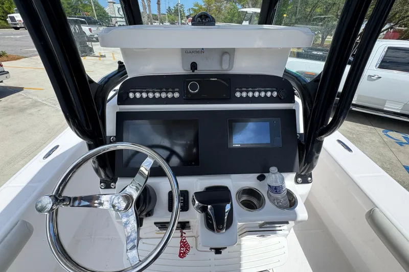 Slide: The Image of 2022 Everglades 243 Center Console boat dashboard with steering wheel and navigation screens. - 27
