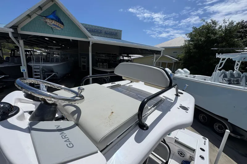 Slide: The Image of 2022 Everglades 243 Center Console boat at a marina under a clear blue sky. - 32