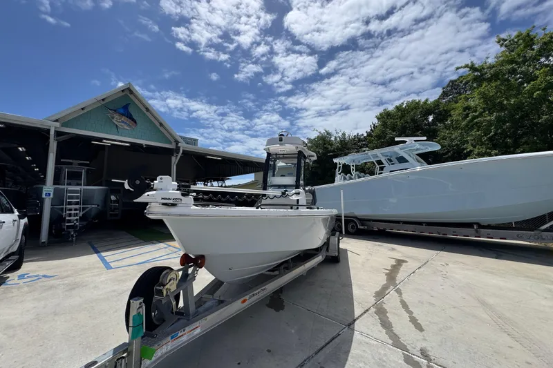 Slide: The Image of 2022 Everglades 243 Center Console boat on trailer under a partly cloudy sky. - 4