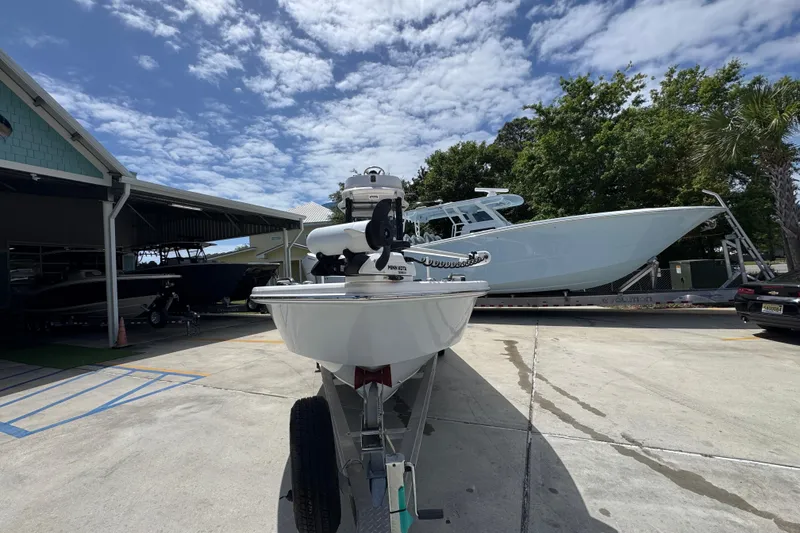 Slide: The Image of 2022 Everglades 243 Center Console boat on trailer, parked outdoors under a partly cloudy sky. - 5