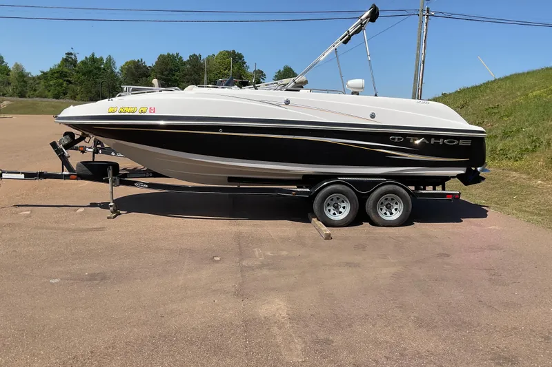 The Image of 2011 Tahoe 225 boat on trailer, parked outdoors on a sunny day. - 0