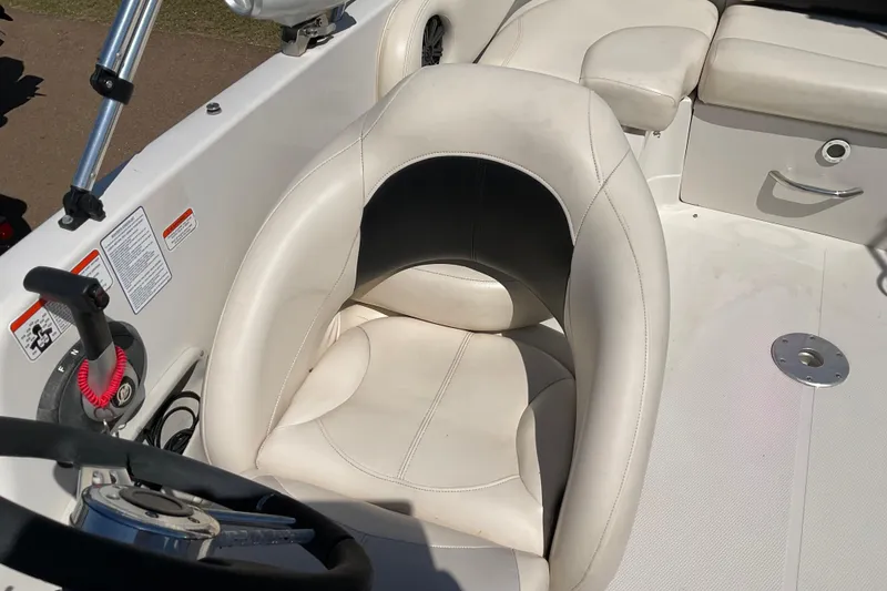 Slide: The Image of Steering area of a 2011 Tahoe 225 boat with white seating and controls. - 12