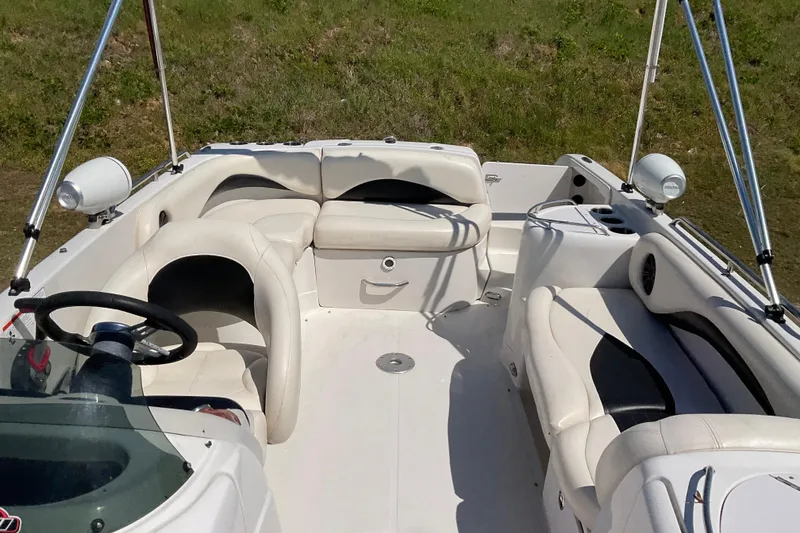 Slide: The Image of Interior of a 2011 Tahoe 225 boat with white seating and steering wheel. - 3