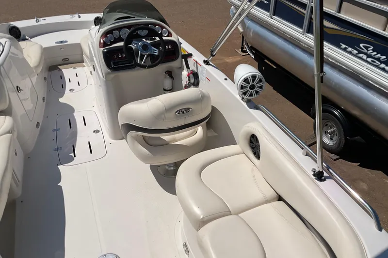 Slide: The Image of Interior of a 2011 Tahoe 225 boat with white seating and steering console. - 5