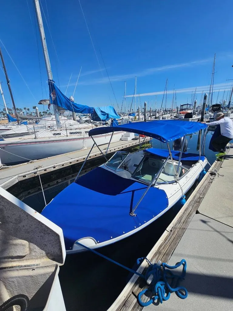 Slide: The Image of 1995 Sea Ray 19 Open Bow boat docked with blue cover. - 1