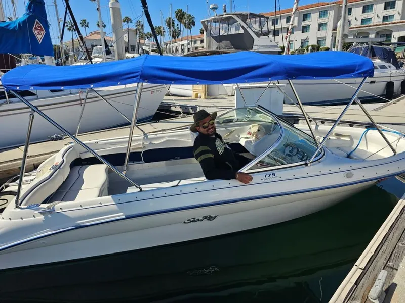 Slide: The Image of 1995 Sea Ray 19 Open Bow boat docked with blue canopy. - 3