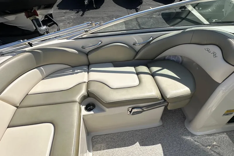 Slide: The Image of 2005 Sea Ray 200 Sundeck interior with beige seating and cup holder. - 5