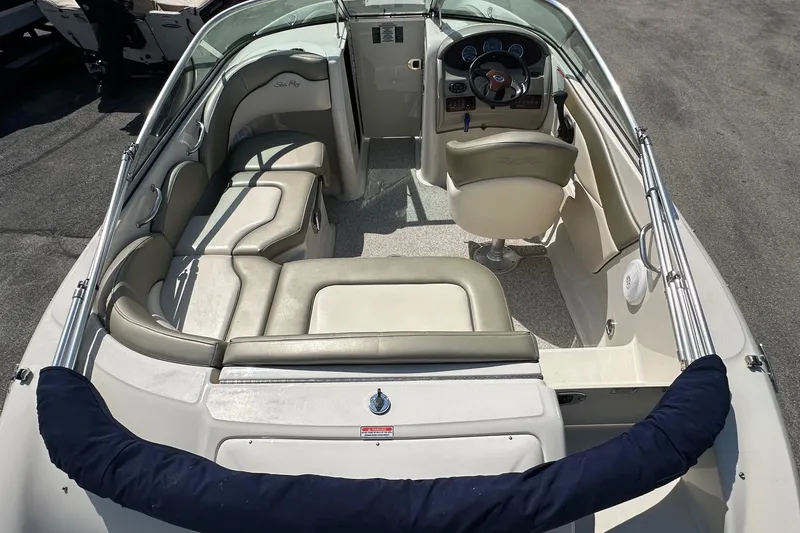 Slide: The Image of 2005 Sea Ray 200 Sundeck interior with beige seating and steering console. - 8