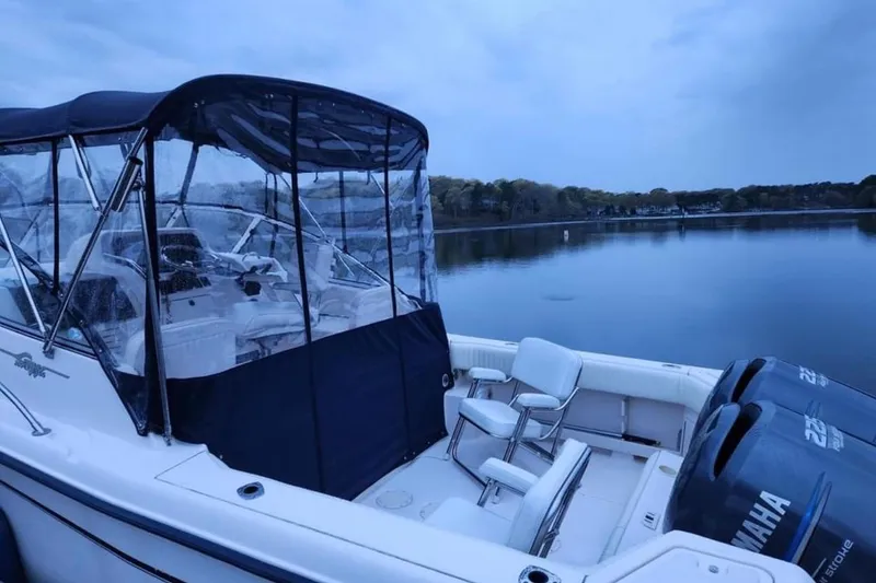 Slide: The Image of 2004 Grady-White Express 265 boat with Yamaha engines on a serene lake. - 2