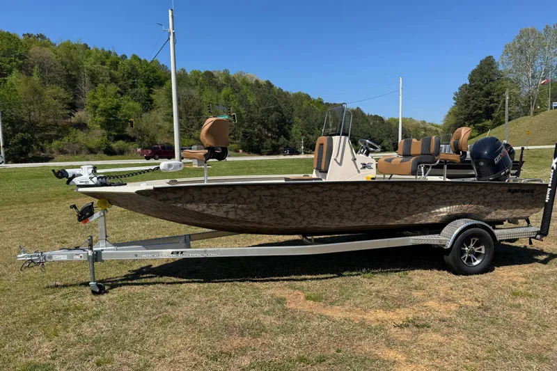 The Image of 2026 Xpress H20B Bay boat on trailer, parked on grass with trees in background. - 0