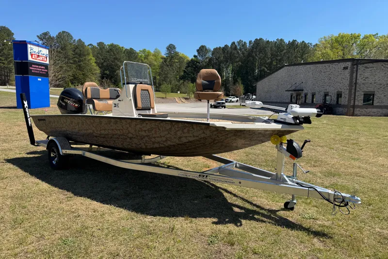 Slide: The Image of 2026 Xpress H20B Bay boat on trailer, parked outdoors near a building. - 13
