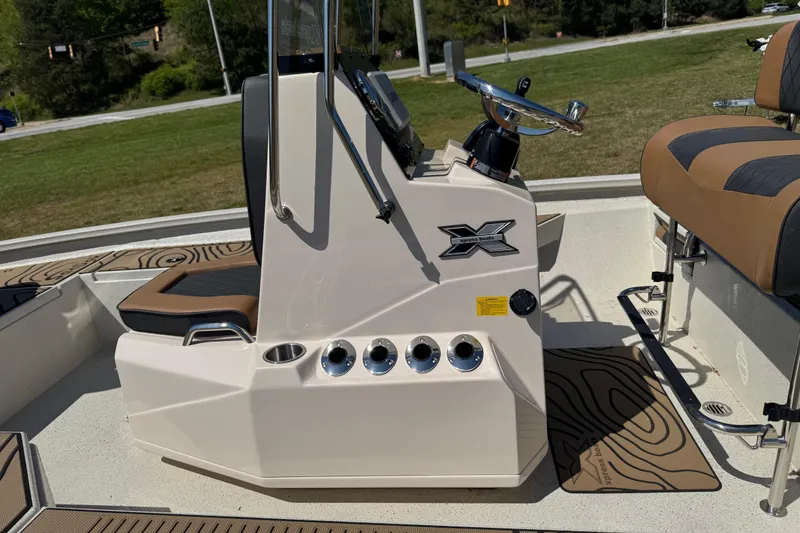 Slide: The Image of 2026 Xpress H20B Bay boat console with steering wheel and seating, outdoors. - 6