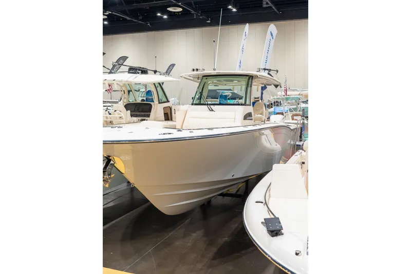 Slide: The Image of 2026 Grady-White Canyon 326 boat displayed at an indoor exhibition. - 2