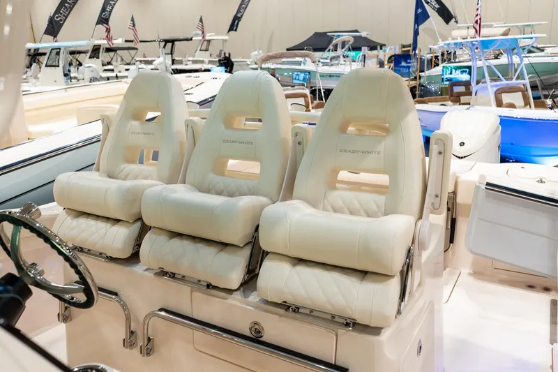 Slide: The Image of 2026 Grady-White Canyon 326 boat with luxurious white seating at a boat show. - 28