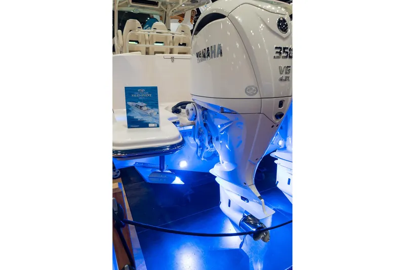 Slide: The Image of 2026 Grady-White Canyon 326 boat with Yamaha engine, illuminated by blue lights. - 4