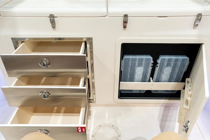 Slide: The Image of 2026 Grady-White Canyon 326 boat storage with open drawers and tackle boxes. - 9