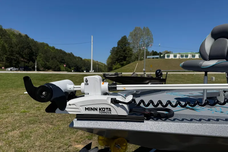 Slide: The Image of 2025 Xpress H20B Bay boat with Minn Kota Terrova trolling motor on grassy area. - 2