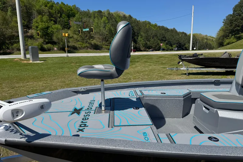 Slide: The Image of 2025 Xpress H20B Bay boat with seating, displayed outdoors on grass. - 5