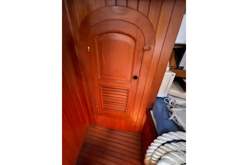 Slide: The Image of Wooden interior of 1981 Hans Christian MKII sailboat, featuring a classic door and nautical ropes. - 11