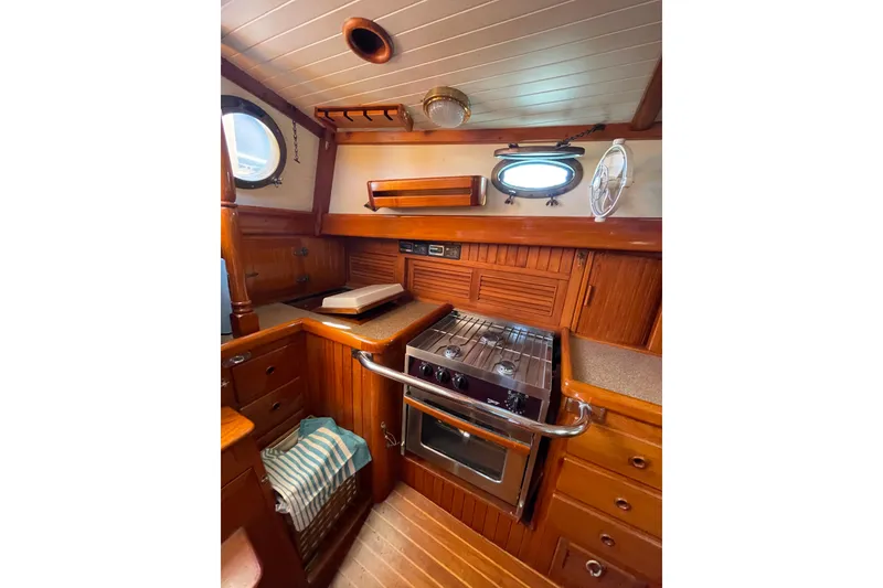 Slide: The Image of 1981 Hans Christian MKII yacht kitchen with wooden cabinetry and stainless steel stove. - 14
