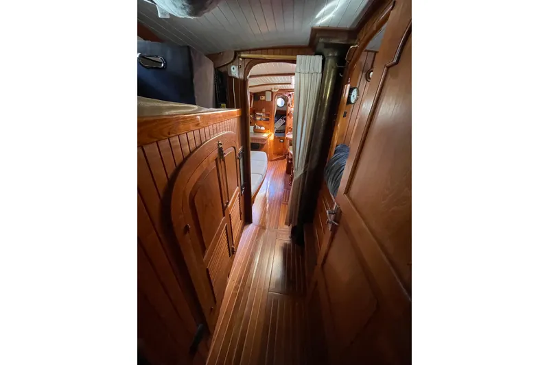 Slide: The Image of Interior of 1981 Hans Christian MKII sailboat, featuring wooden paneling and cozy cabin layout. - 23