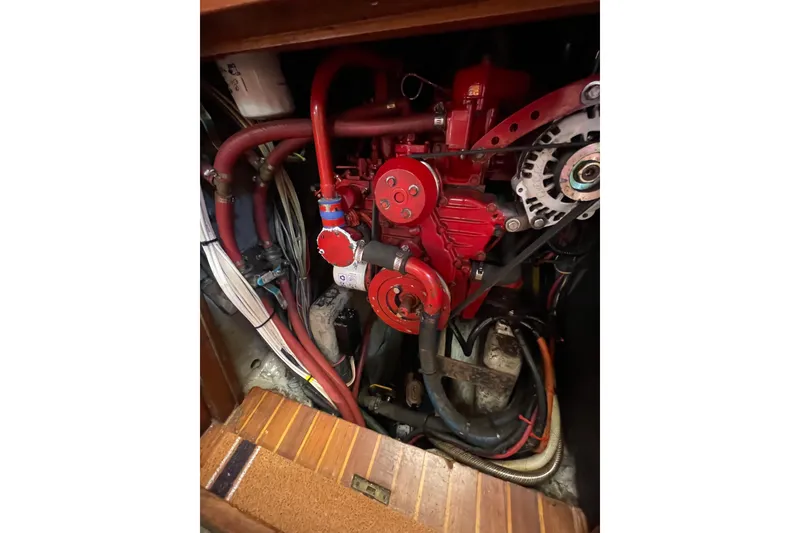 Slide: The Image of Engine compartment of a 1981 Hans Christian MKII sailboat, featuring red mechanical components. - 28