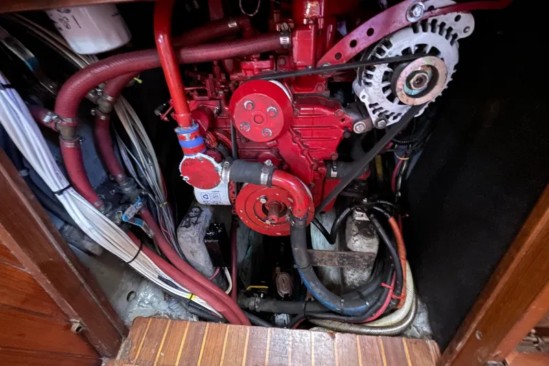 Slide: The Image of Engine compartment of a 1981 Hans Christian MKII sailboat, featuring red engine components and wiring. - 29