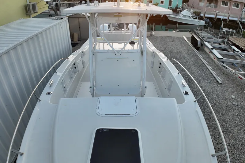 Slide: The Image of 2003 Pro Sports 2860 SC ProKat boat docked, showcasing spacious deck and helm area. - 12