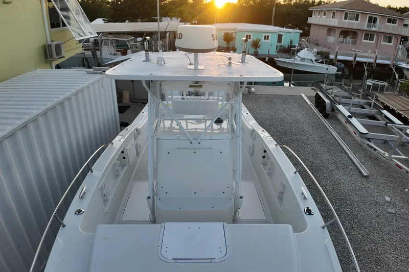 Slide: The Image of 2003 Pro Sports 2860 SC ProKat boat docked at sunset, surrounded by buildings. - 13