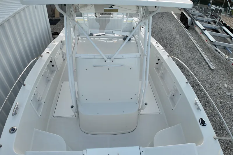 Slide: The Image of 2003 Pro Sports 2860 SC ProKat boat, white deck, center console, docked on gravel. - 14