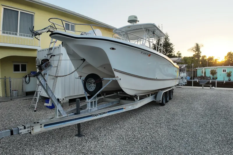 Slide: The Image of 2003 Pro Sports 2860 SC ProKat boat on trailer, parked in gravel driveway. - 2