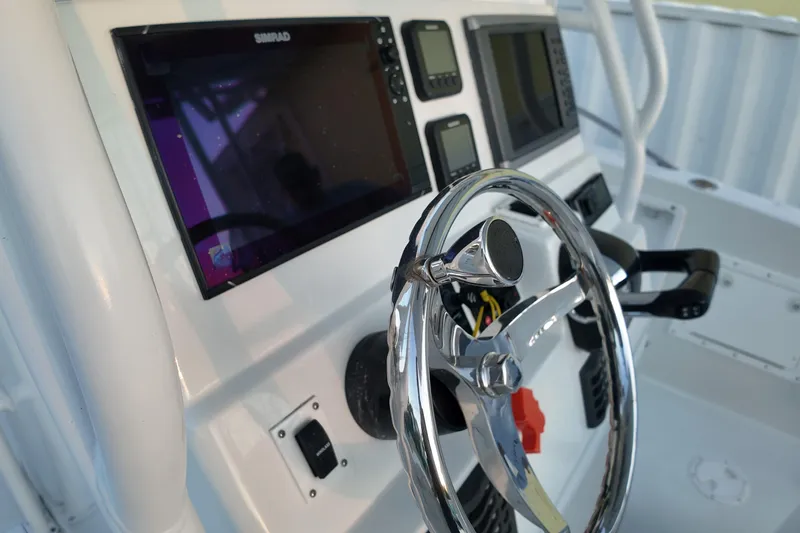 Slide: The Image of 2003 Pro Sports 2860 SC ProKat boat dashboard with steering wheel and navigation screens. - 8