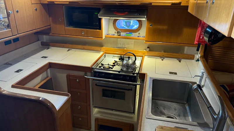 Slide: The Image of Galley kitchen in 2004 Catalina 470 yacht with stove, sink, and microwave. - 15