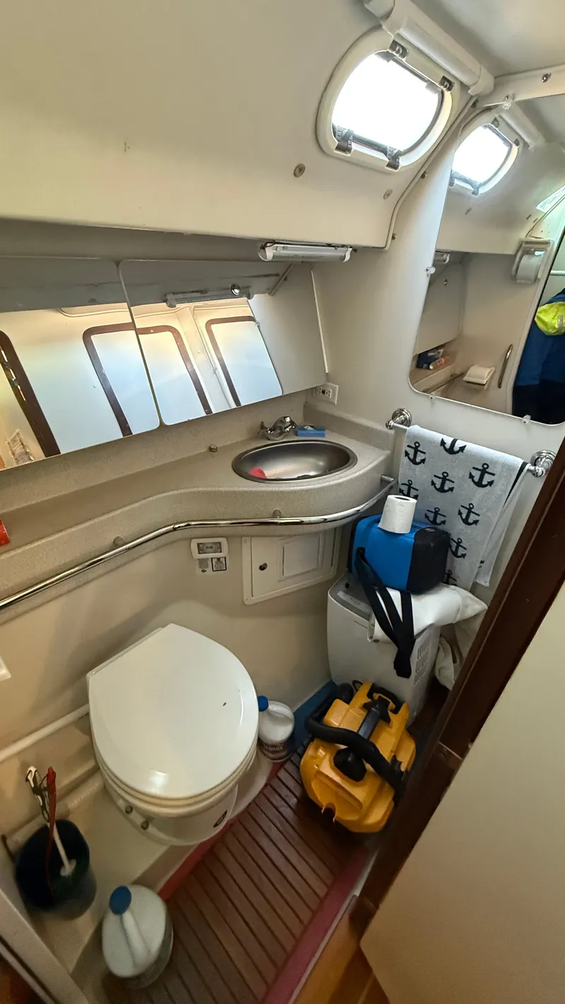 Slide: The Image of Catalina 470 yacht bathroom, 2004 model, featuring toilet, sink, and nautical-themed decor. - 22