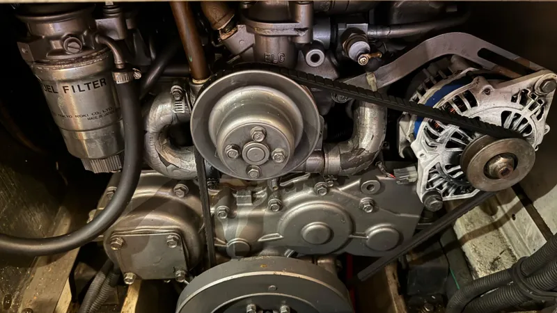 Slide: The Image of Engine components of a 2004 Catalina 470, featuring a diesel filter and alternator belt. - 24