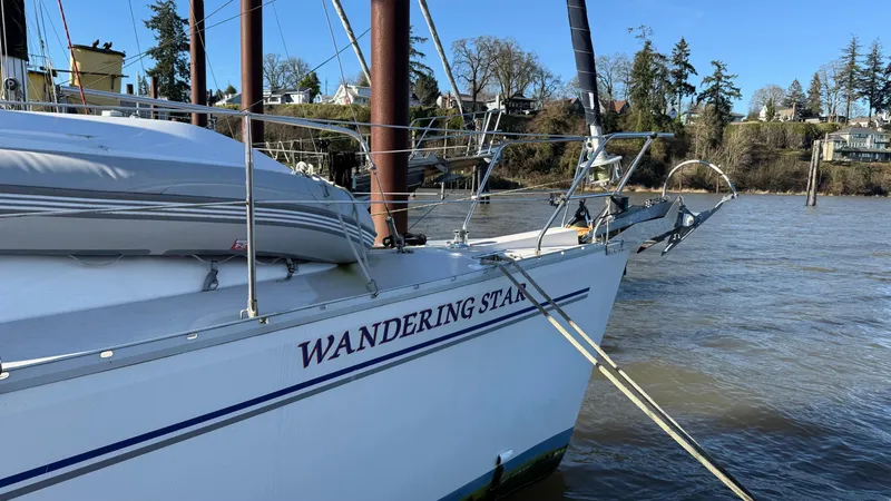 Slide: The Image of Catalina 470 sailboat named "Wandering Star" docked by a riverbank, 2004 model. - 28