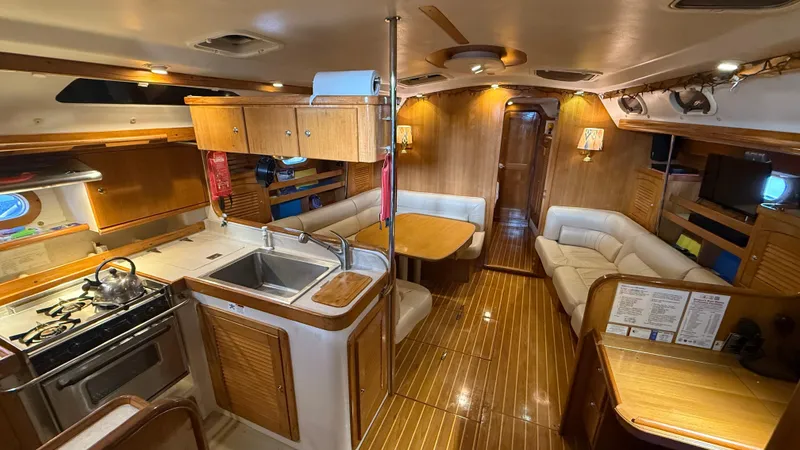 Slide: The Image of Interior of 2004 Catalina 470 yacht with kitchen, dining area, and cozy seating. - 3