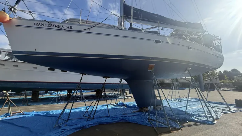 Slide: The Image of Catalina 470 sailboat from 2004 on stands, named "Wandering Star," in a boatyard. - 34