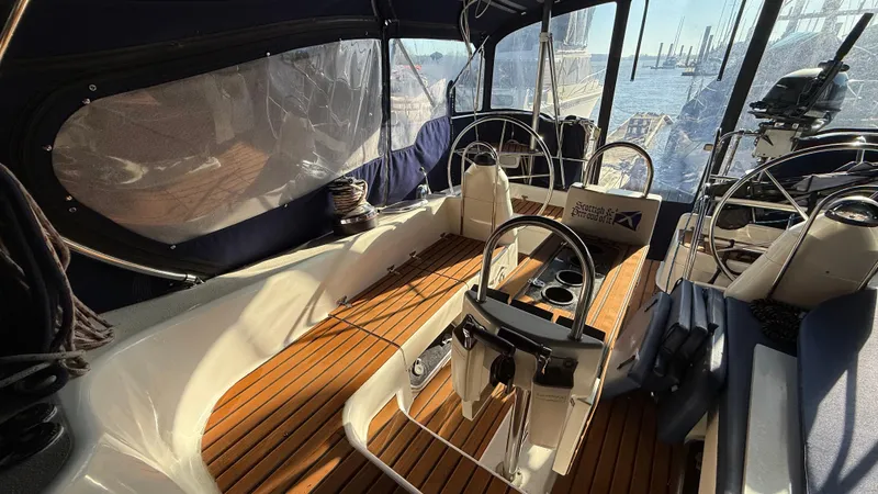 Slide: The Image of 2004 Catalina 470 yacht cockpit with wooden flooring and dual steering wheels. - 36