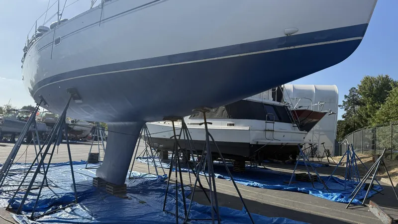 Slide: The Image of Catalina 470 sailboat from 2004 on stands, undergoing maintenance in a boatyard. - 43