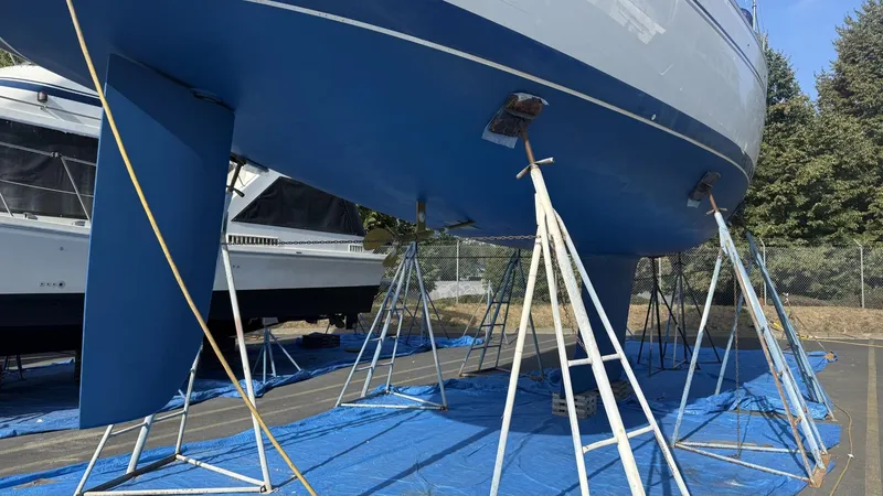 Slide: The Image of 2004 Catalina 470 sailboat on stands, blue hull, outdoor storage. - 45