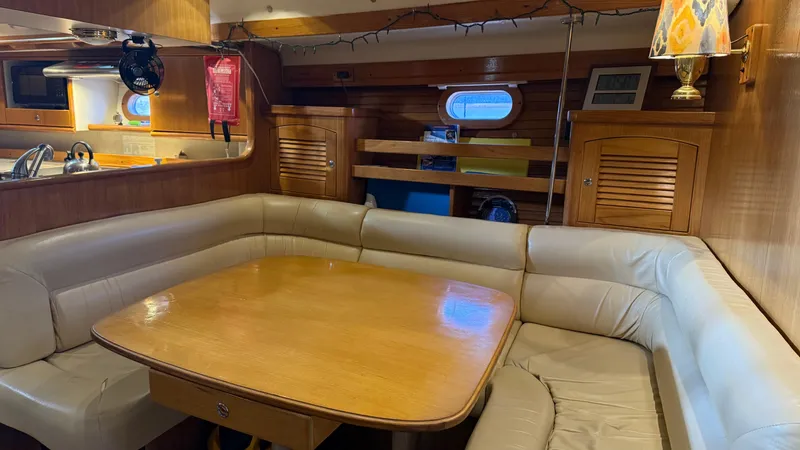 Slide: The Image of Interior of 2004 Catalina 470 yacht with cozy dining area and wooden finishes. - 5